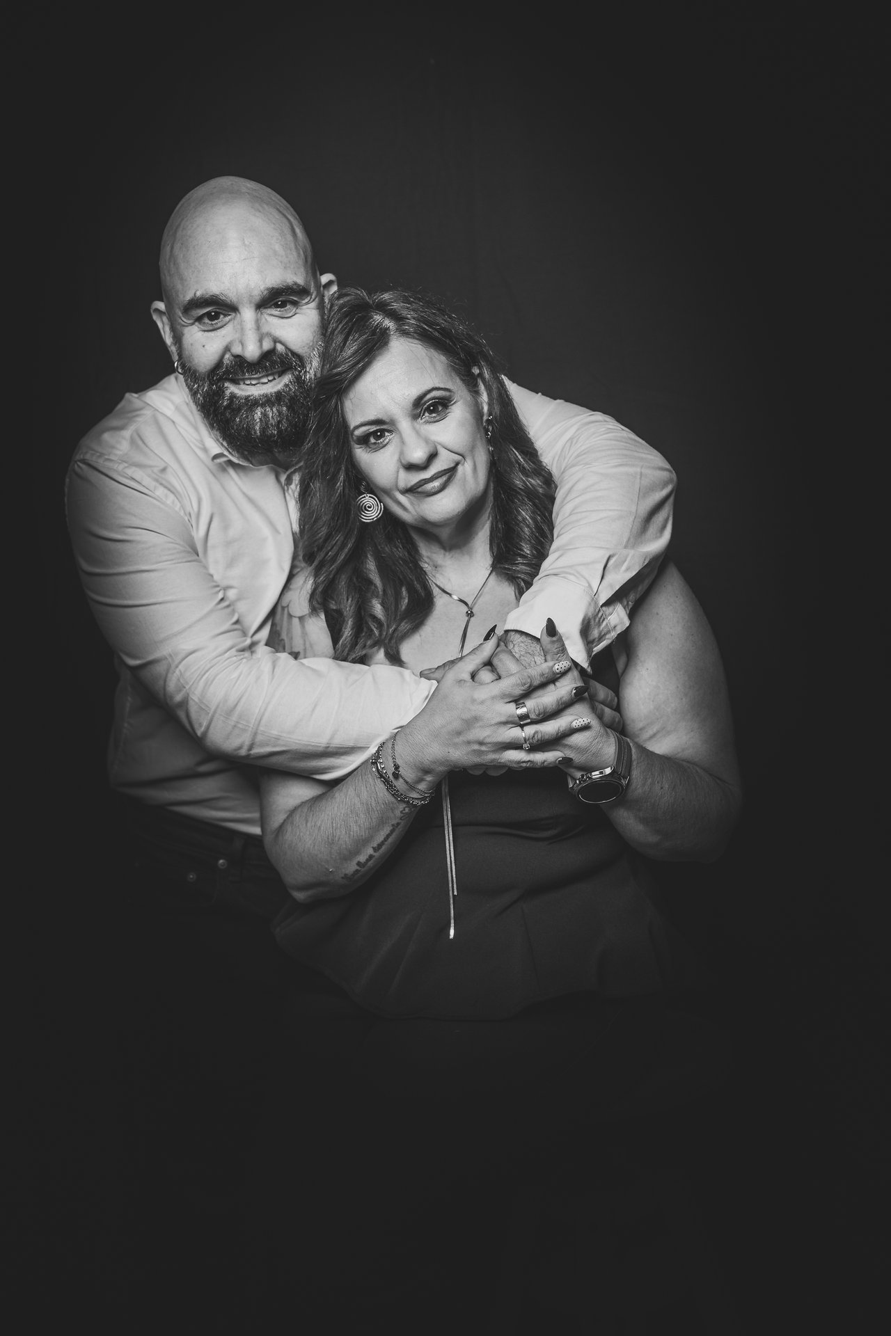 Retrato de pareja abrazada con fondo negro