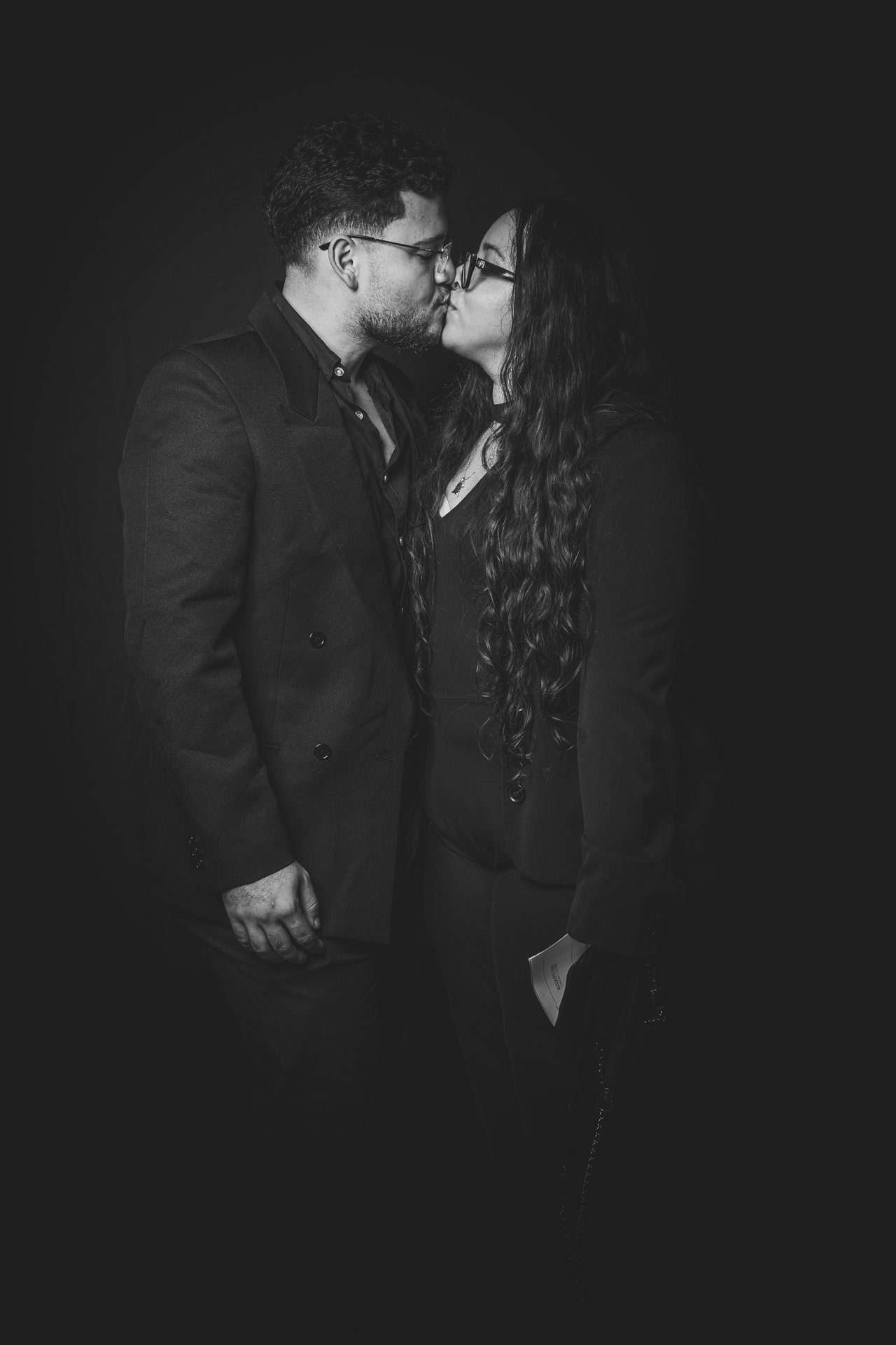 Retrato de pareja besándose con fondo negro