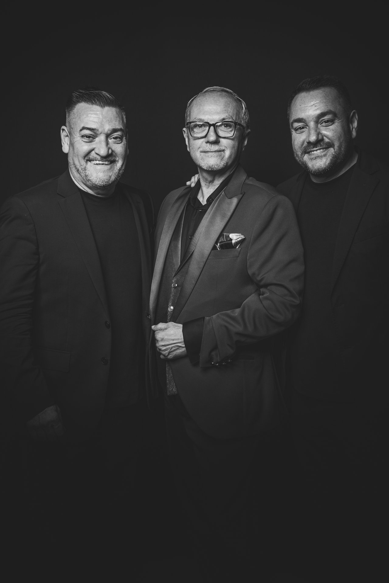 Retrato editorial de tres invitados con fondo negro