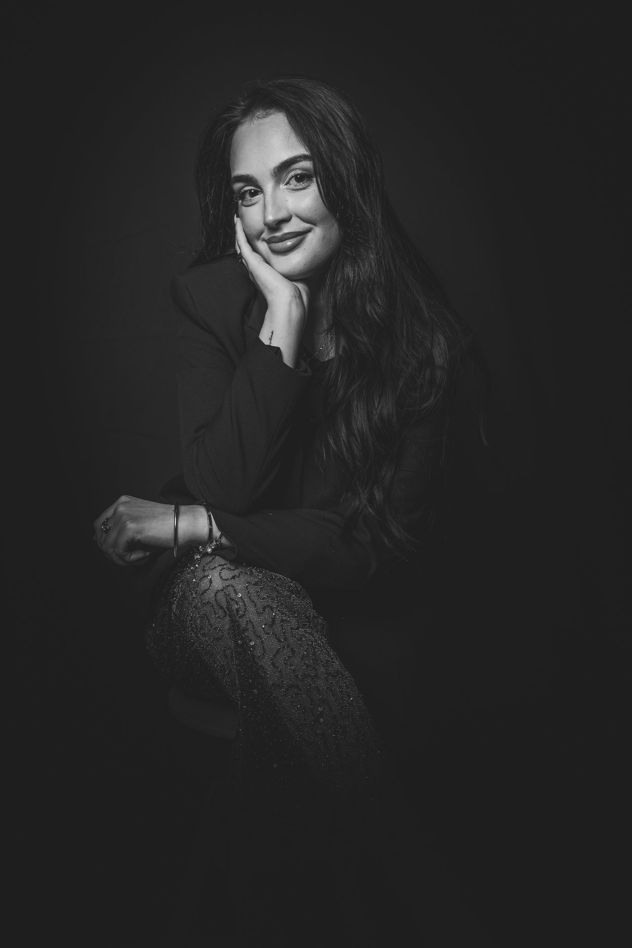 Retrato editorial de una invitada con iluminación de estudio y fondo negro